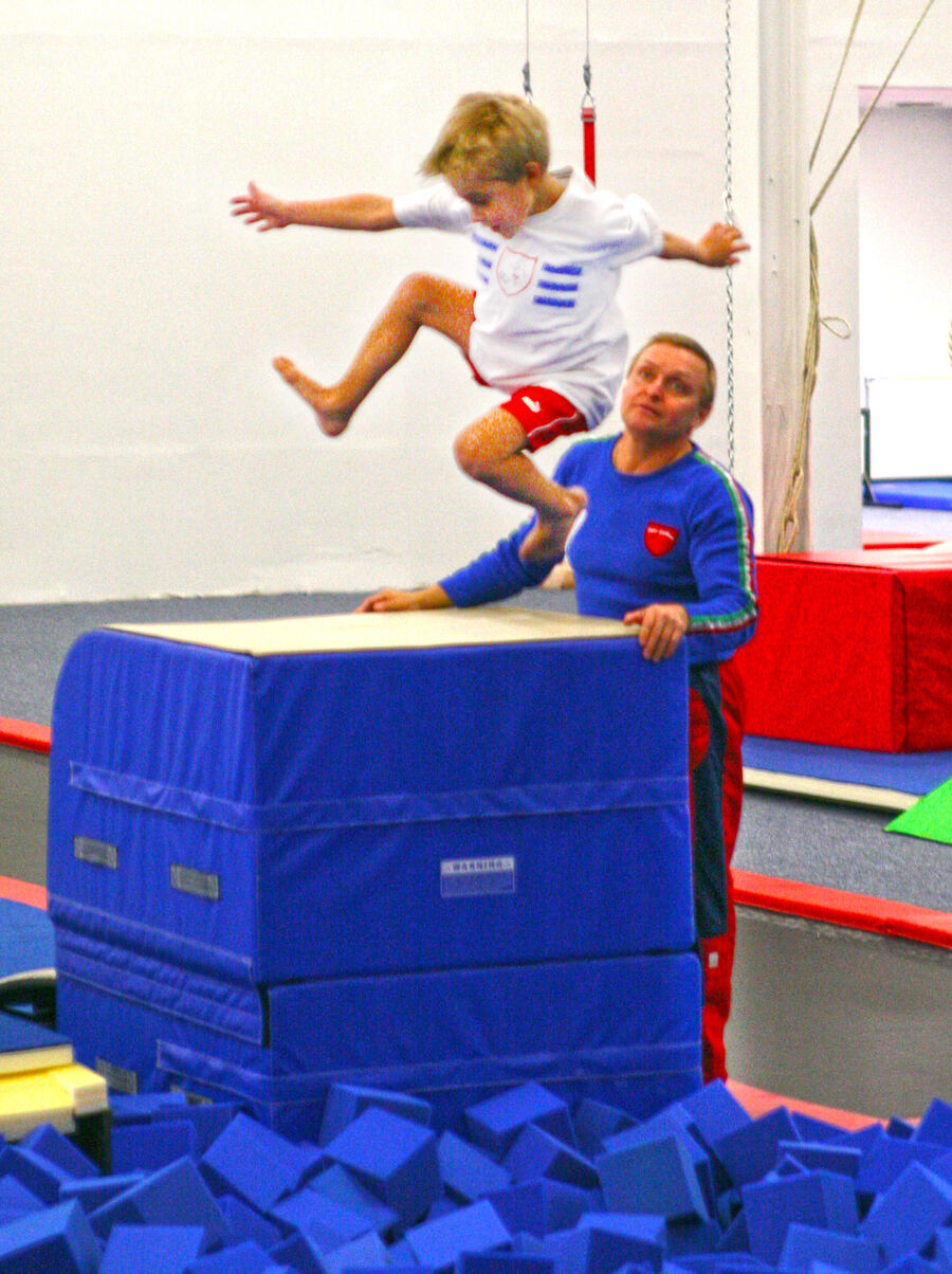Coach working with a young gymnast